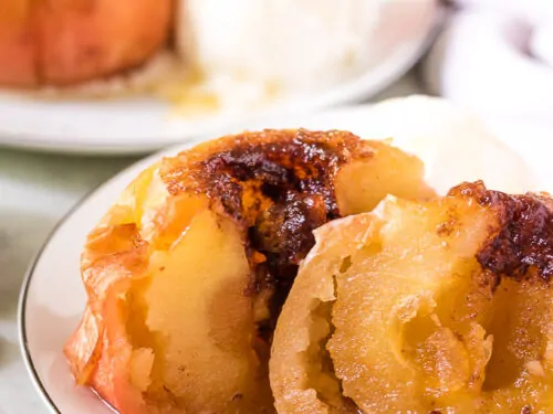 The baked apple has been cut in half to show the center.