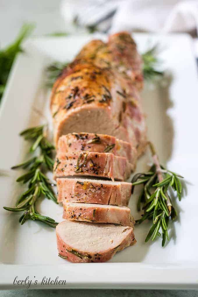 The meat has finished cooking and is served on a long plate.