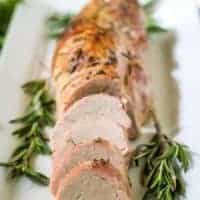 The sliced pork tenderloin being served on a rectangular platter.