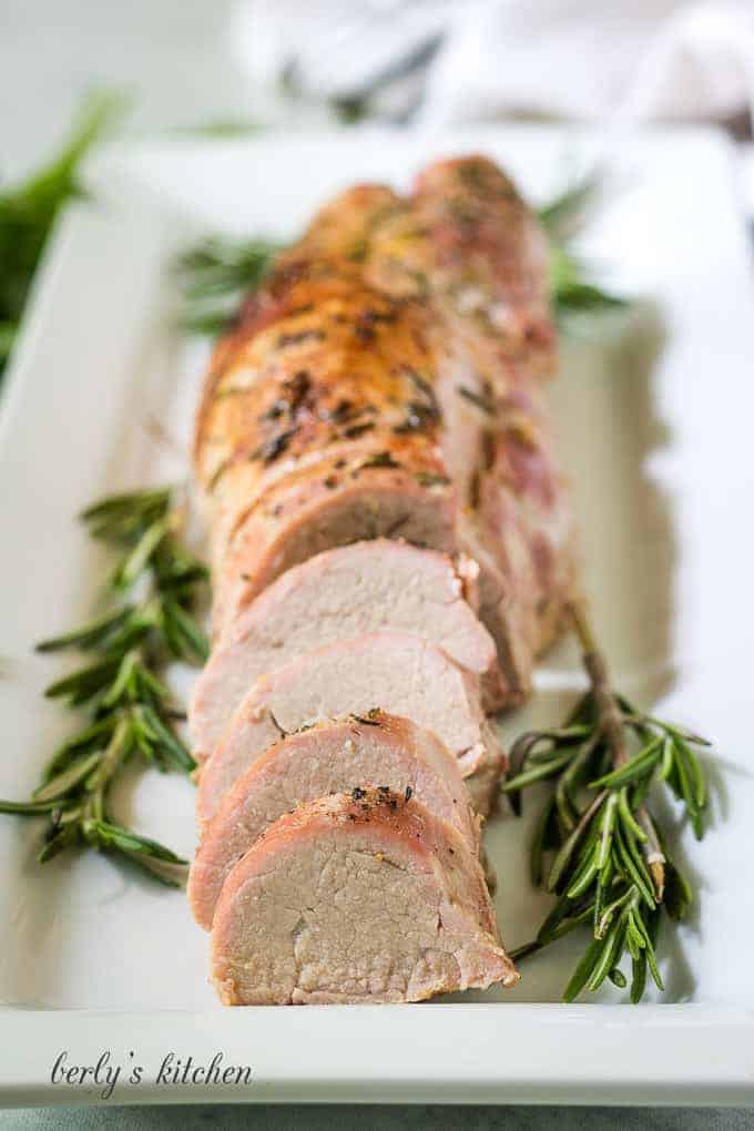 The sliced pork tenderloin being served on a rectangular platter.