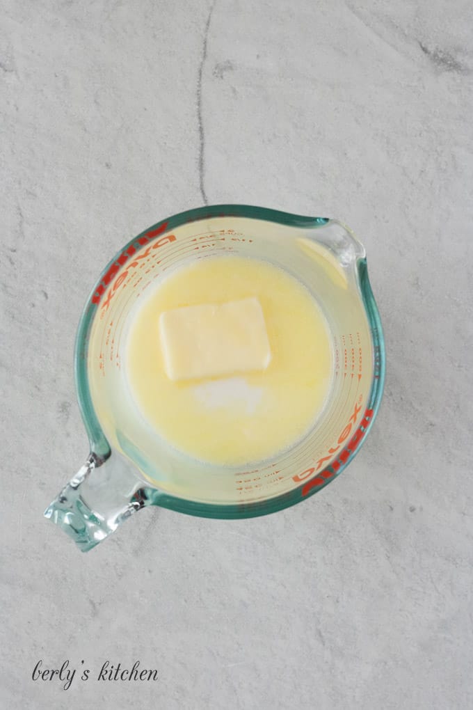 Butter, milk, and water in a large glass measuring cup.