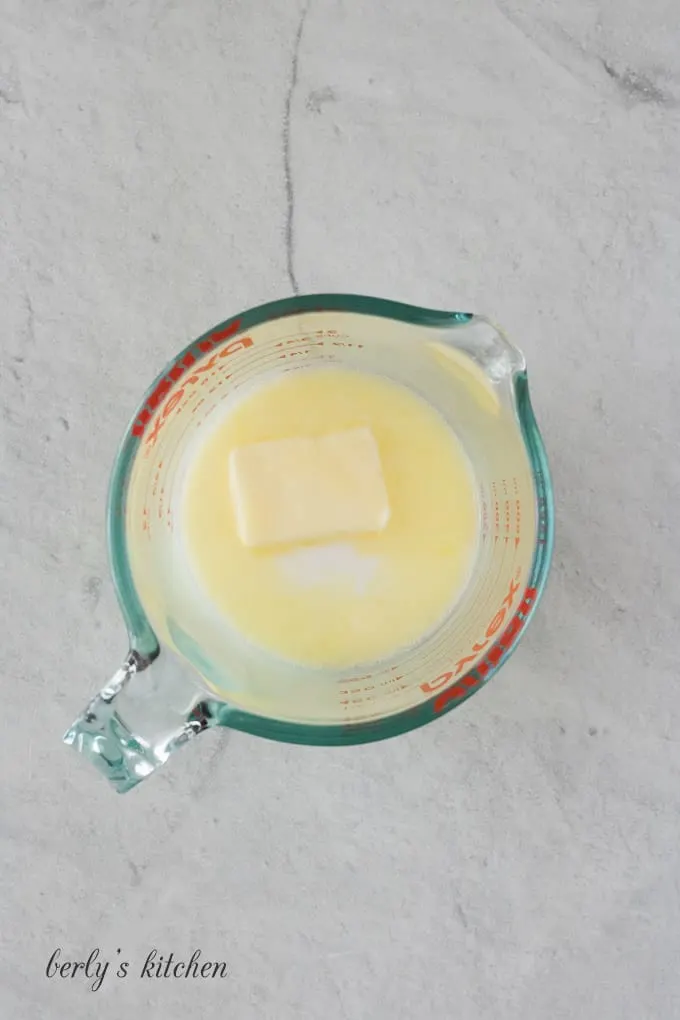 Butter, milk, and water in a large glass measuring cup.