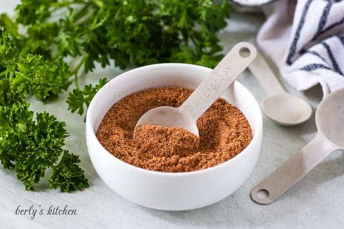 The fajita seasoning in a bowl with a measuring spoon.