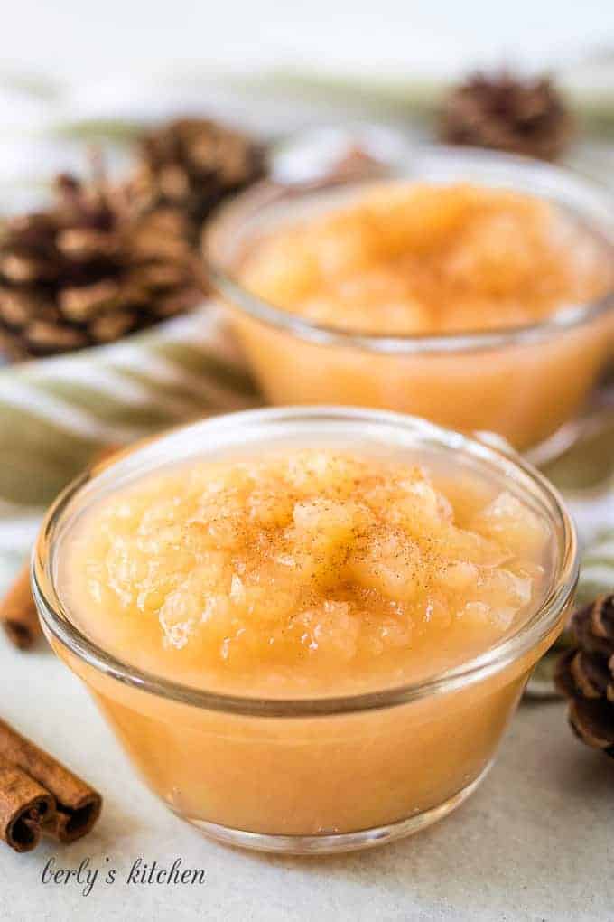 Two small ramekins of instant pot applesauce with ground cinnamon.