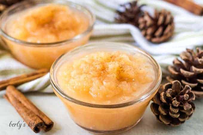 The finished applesauce in a ramekin surrounded by cinnamon sticks.