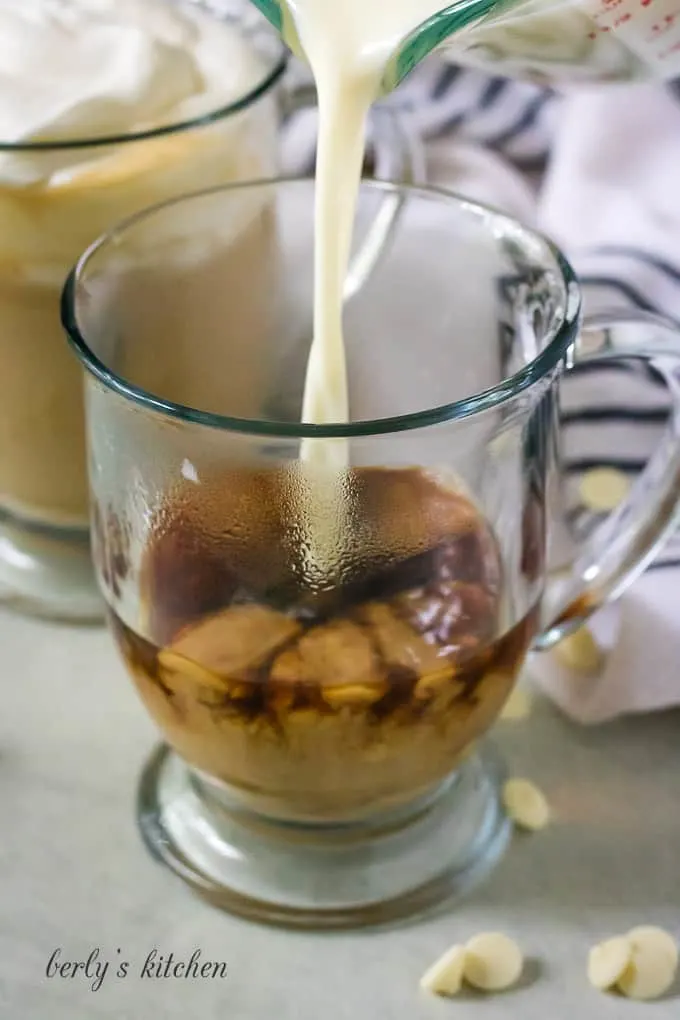 The milk mixture being added to a mug of coffee,