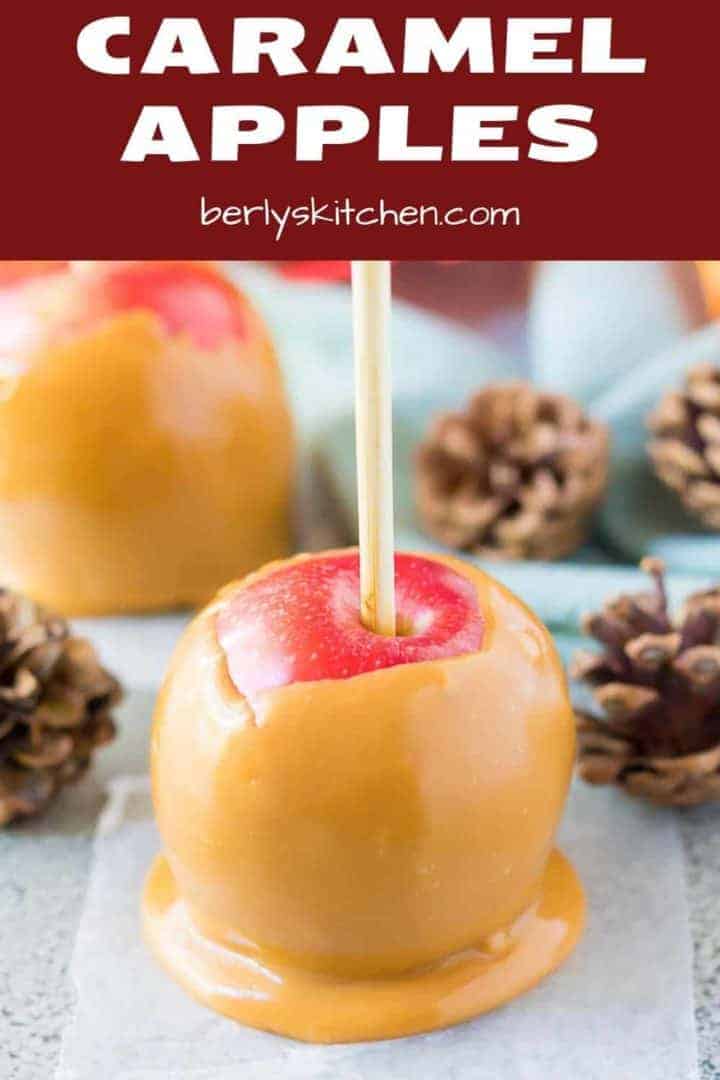 The caramel apple cooling on wax paper with fall decor.