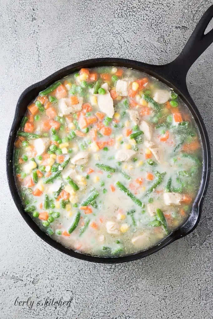 Mixed vegetables have been added to the skillet to cook.