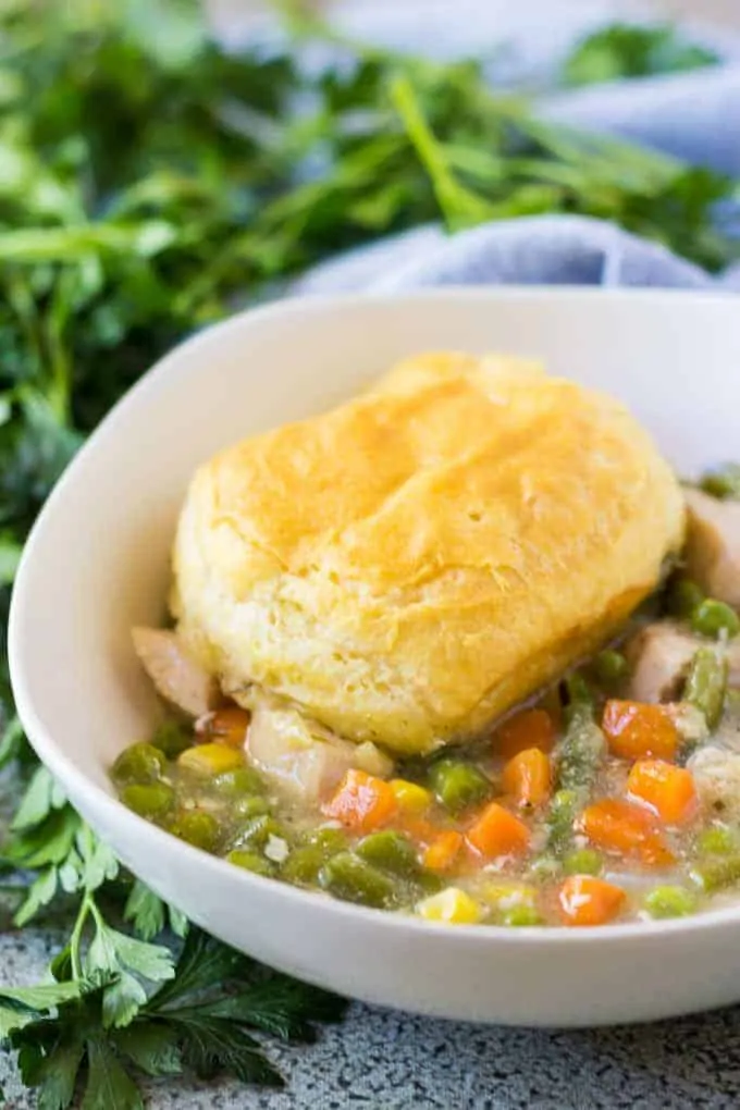 Chicken pot pie topped with a biscuit in a bowl.