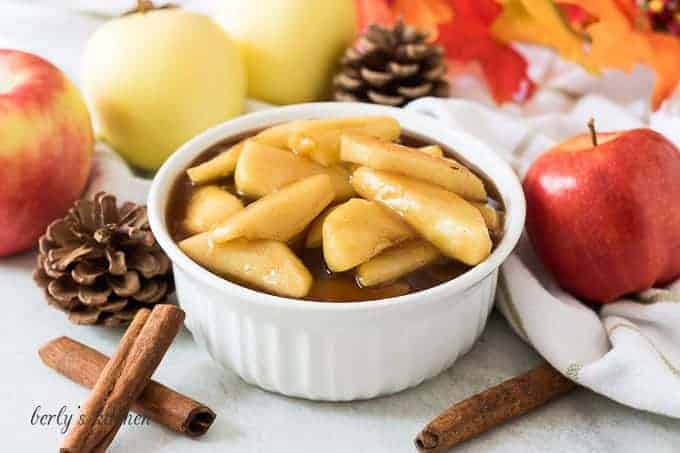 A bowl of the cinnamon apples accented with cinnamon sticks.