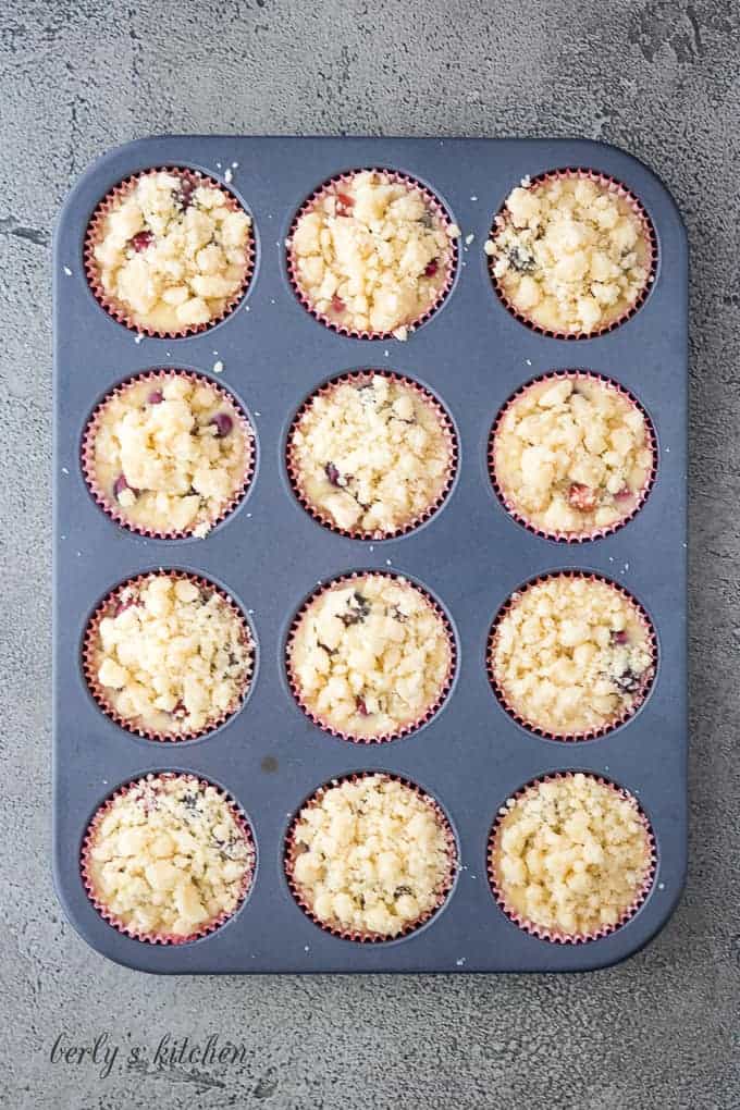 The unbaked cranberry orange muffins topped with the crumble topping.