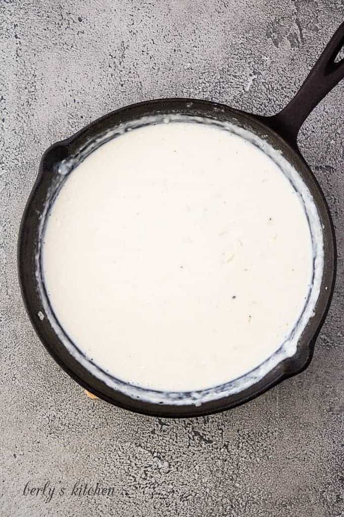 The casserole sauce simmering in a large cast iron pan.