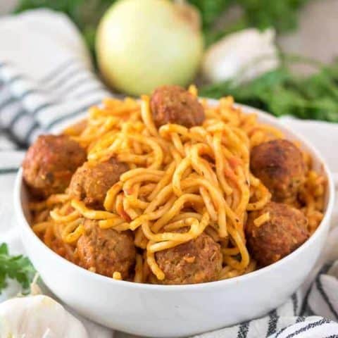 The spaghetti with meatballs served in a decorative white bowl.