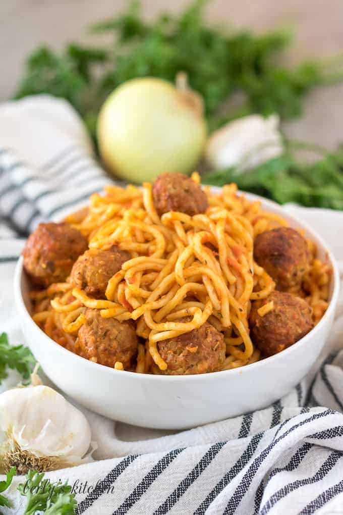 The spaghetti with meatballs served in a decorative white bowl.