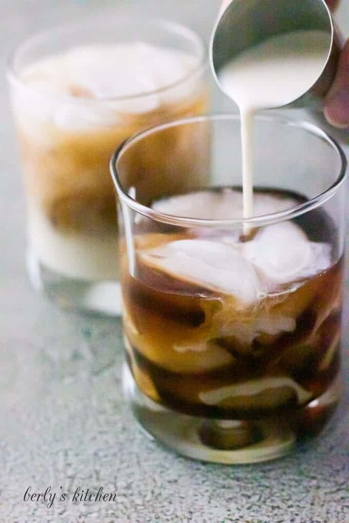 The coffee creamer being added to the vodka and kahlua.