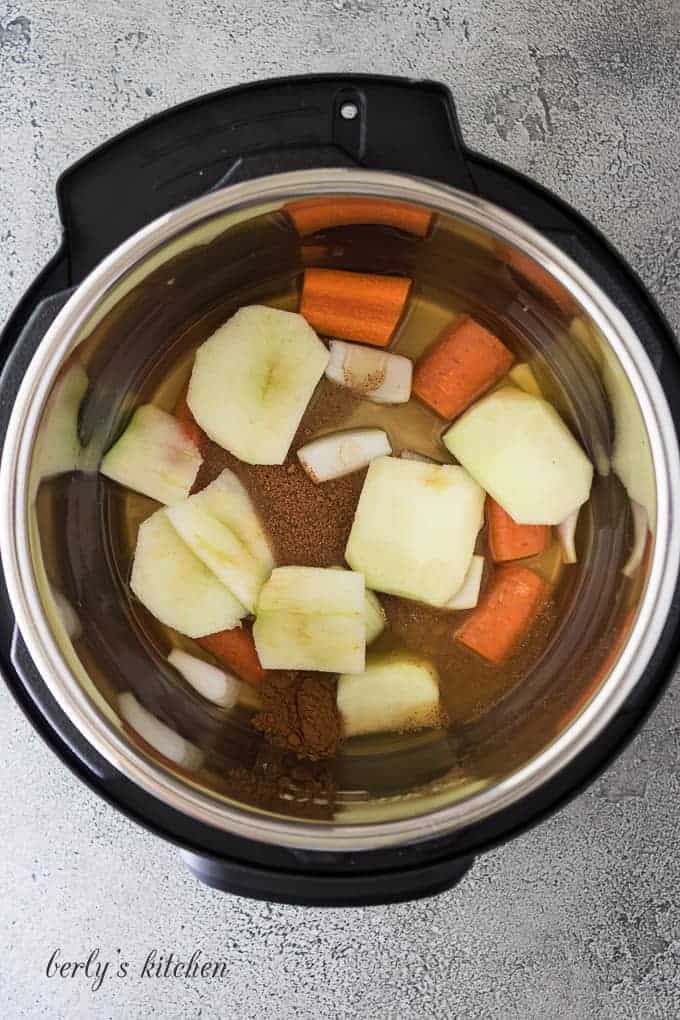 Apples, carrots, and other ingredients in the pressure cooker liner.