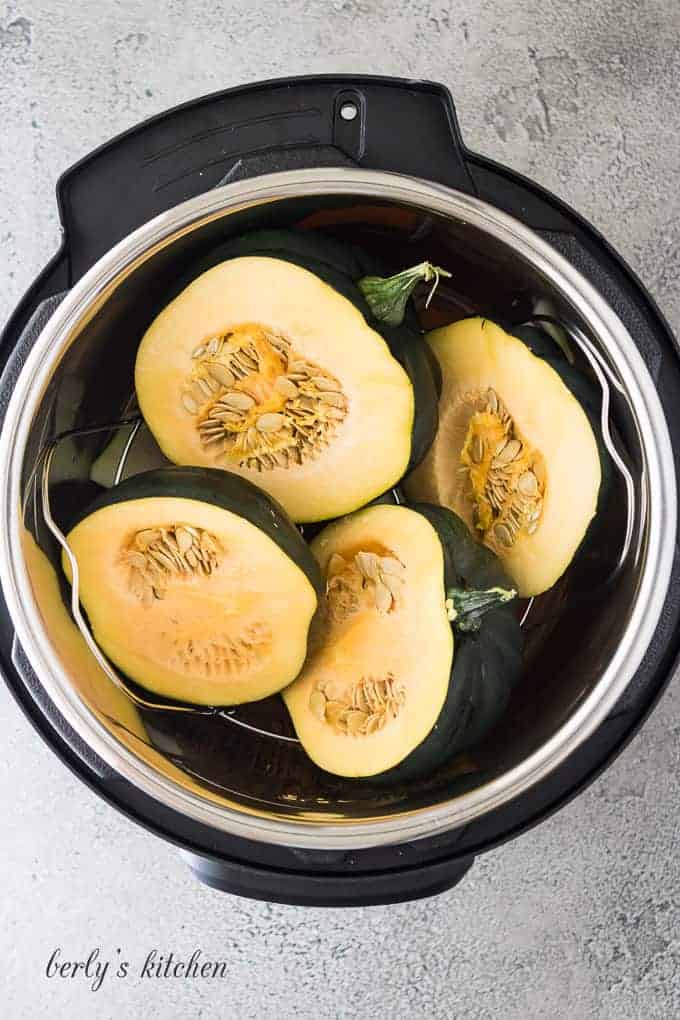 The acorn squash has been added to the cooker liner.