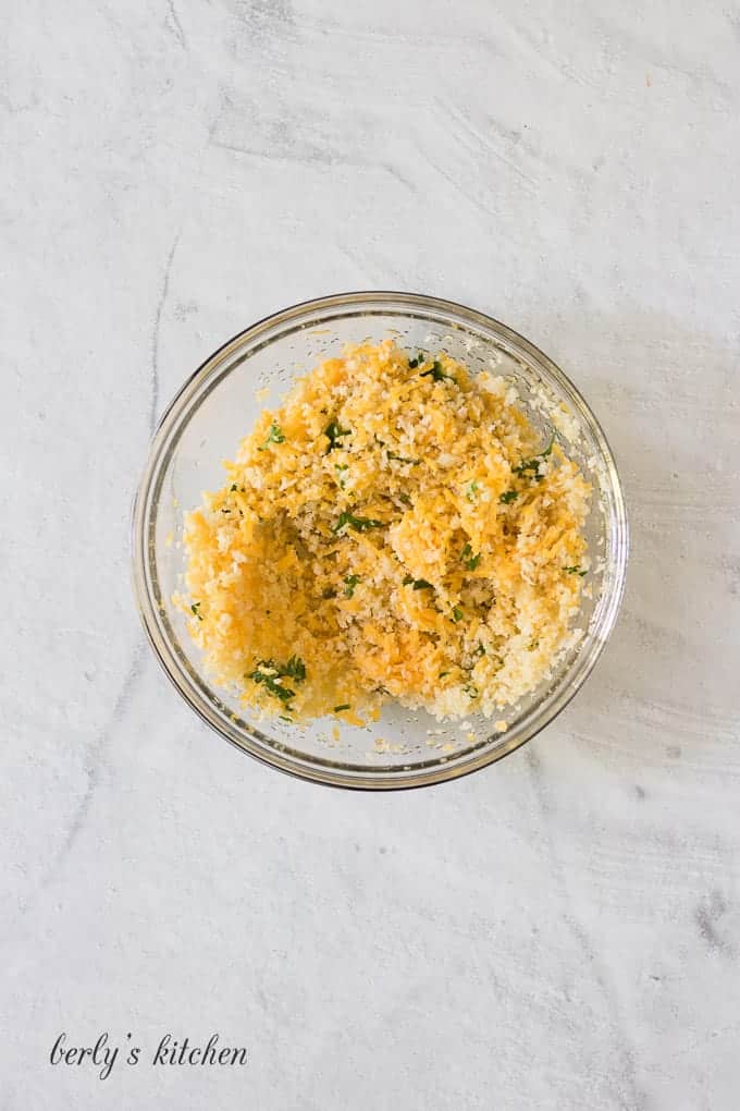 The breadcrumbs and seasonings mixed in a small glass ramekin.