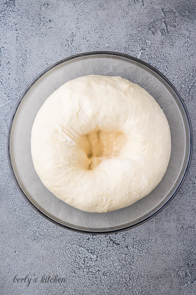 Punching down the dough to deflate it before making rolls.