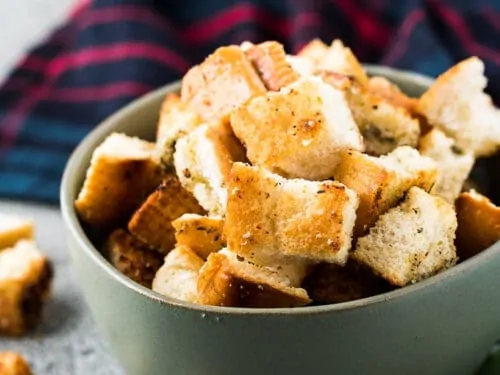 A close-up of the finished croutons in a green bowl.