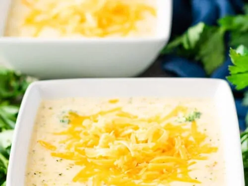 Two square bowls filled with the finished broccoli cheese soup.