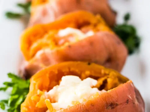 The finished sweet taters split open and topped with butter.