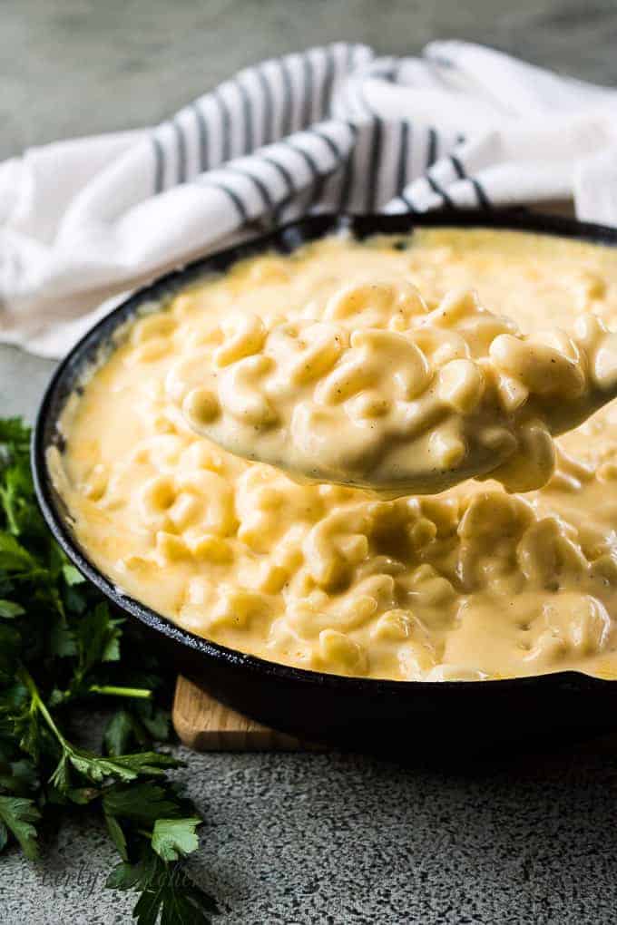 The macaroni and cheese being scooped from the iron skillet.