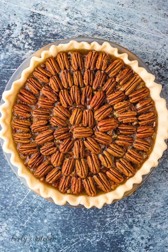 Raw pecans have placed on top the pie for decoration.