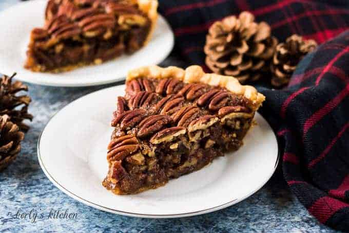 A slice of pecan pie on a small decorative saucer.