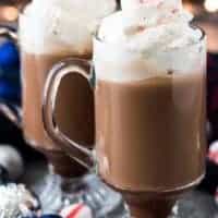 The finished coffees in glass mugs garnished with whipped cream.