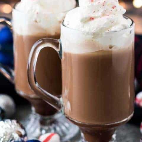 The finished coffees in glass mugs garnished with whipped cream.