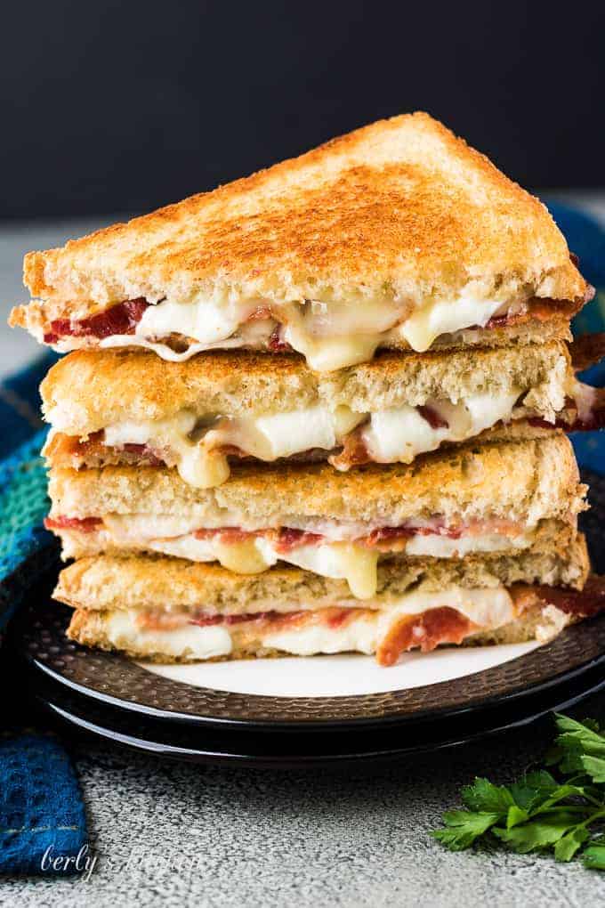 Two sandwiches halved and stacked to show gooey melting cheese.