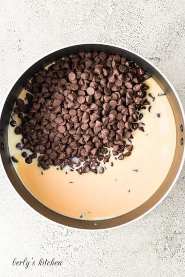 Chocolate chips and other ingredients melting in a large pan.