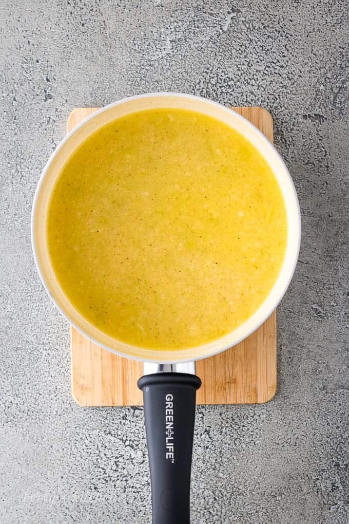 Ariel view of celery, spices, butter, and broth in a saucepan.