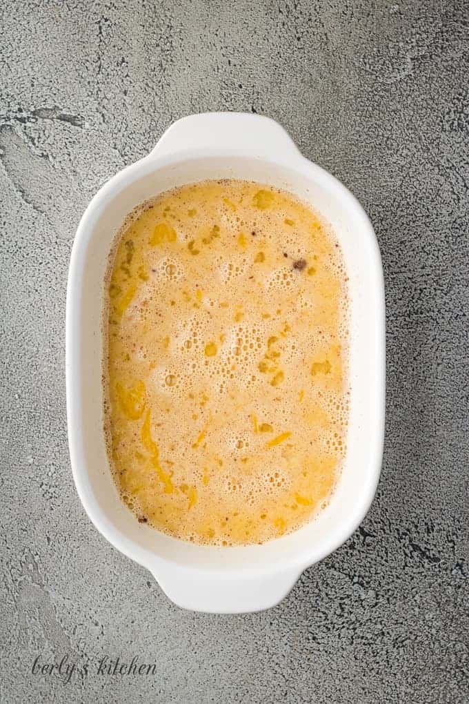 Eggs, eggnog, and other ingredients mixed in a shallow dish.