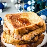 A stack of french toast being drizzled with maple syrup.