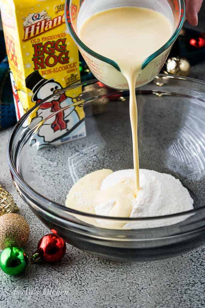 Eggnog being poured into a bowl with instant pudding mix.