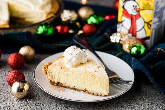 A slice of the eggnog pie surrounded by festive decorations.