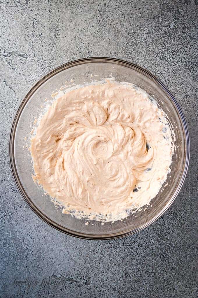 The cream cheese mixture has been blended in the bowl.