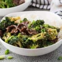 Beef and broccoli in a bowl topped with sesame seeds