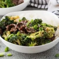 Beef and broccoli in a bowl topped with sesame seeds