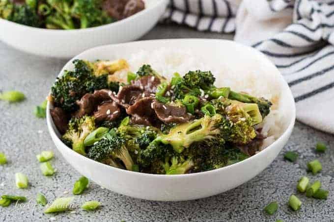 Beef and broccoli in a bowl topped with sesame seeds
