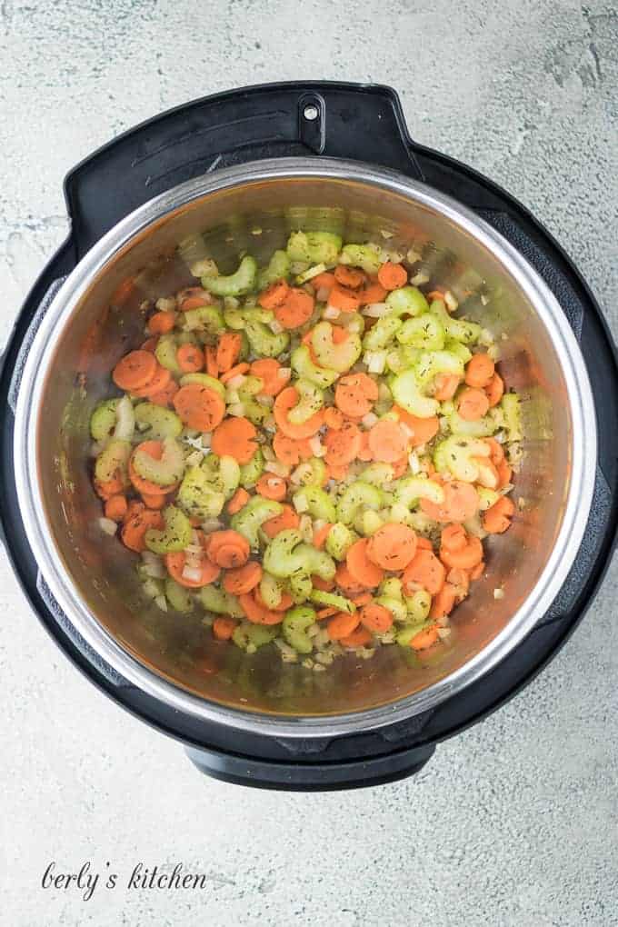 Carrots, celery, and onions sauteing in the stainless steel liner.