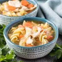 Two decorative bowls of the Instant Pot chicken noodle soup.