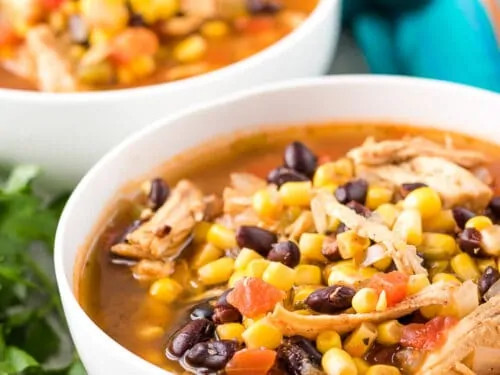 The finished chicken tortilla soup served in large white bowls.