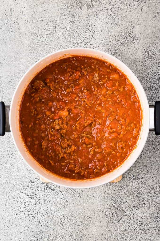 Cooked marinara, beef and other ingredients in a large saucepan.