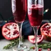 Champagne being poured into the glasses filled with fruit juice.