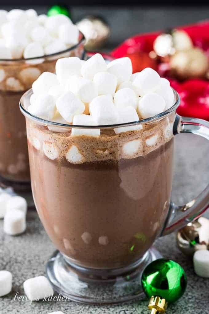 The hot cocoa served in a glass mug with marshmallows.