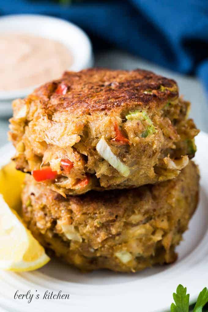 The homemade crab cakes stacked on a small decorative plate.