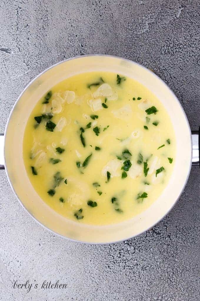 Melted butter, sliced garlic, and parsley in a large saucepan.